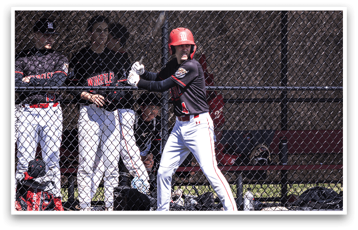 A baseball player in a black and red uniform is swinging a bat. Description generated by AI