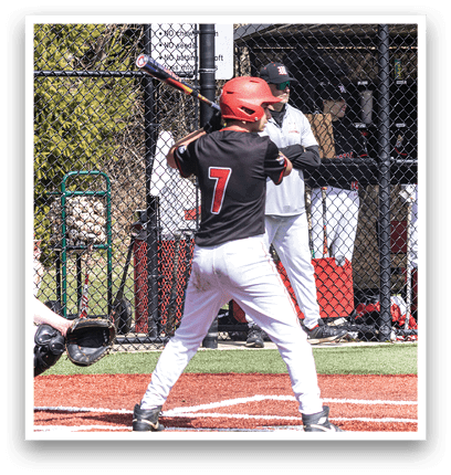 A baseball player is holding a bat and getting ready to hit a ball. Description generated by AI