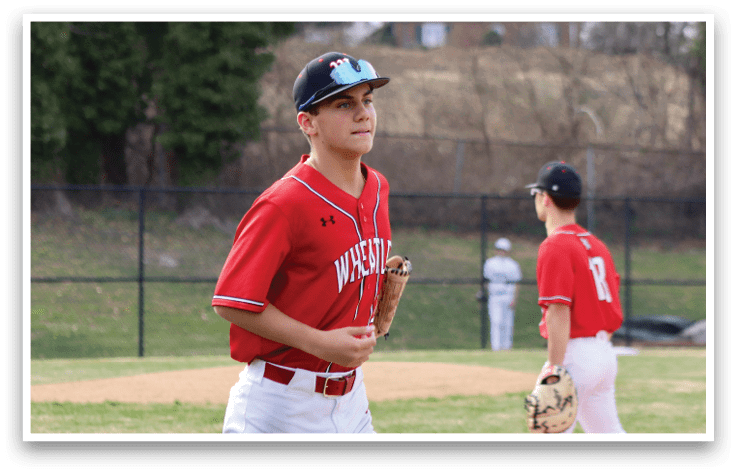 A boy wearing a red shirt and white pants with a baseball glove. Description generated by AI