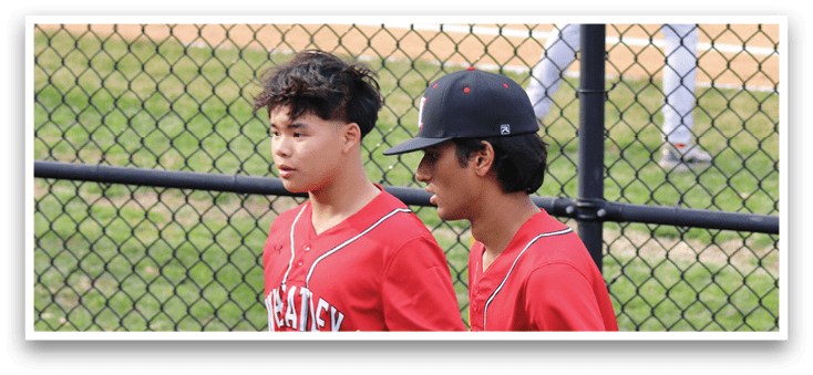 Two baseball players wearing red and white uniforms. Description generated by AI