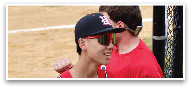 A baseball player wearing a red jersey and a black helmet. Description generated by AI