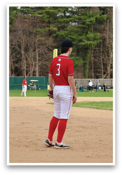 A baseball player wearing a red shirt and white pants. Description generated by AI