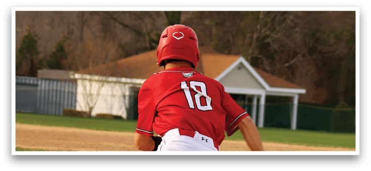 A baseball player in a red shirt and white pants running on a field. Description generated by AI