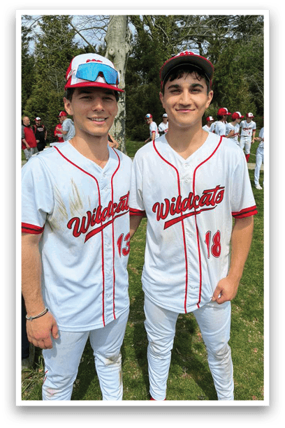 A baseball player wearing a red shirt and white pants. Description generated by AI