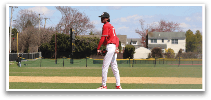 A baseball player wearing a red shirt and white pants catching a ball. Description generated by AI