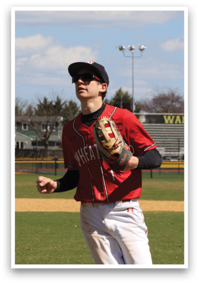 A baseball player wearing a red shirt and white pants. Description generated by AI