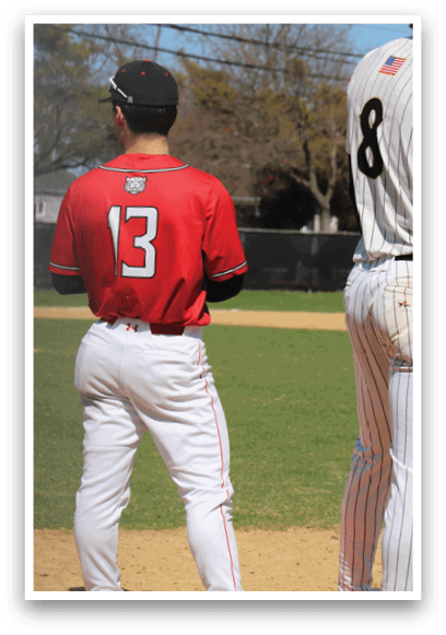 A baseball player wearing a red shirt and white pants. Description generated by AI