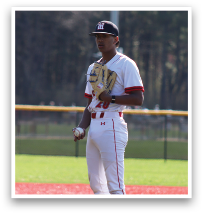 A baseball player in a white uniform is standing on the pitcher's mound. Description generated by AI