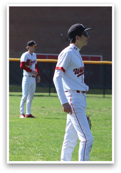 Two baseball players standing on a field. Description generated by AI