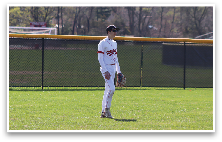 A baseball player standing on the field. Description generated by AI