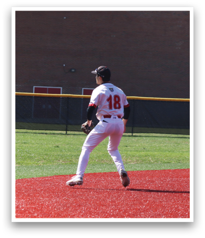 A baseball player in a white uniform is standing on a field. Description generated by AI