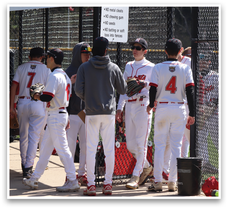 Baseball players standing on a field. Description generated by AI
