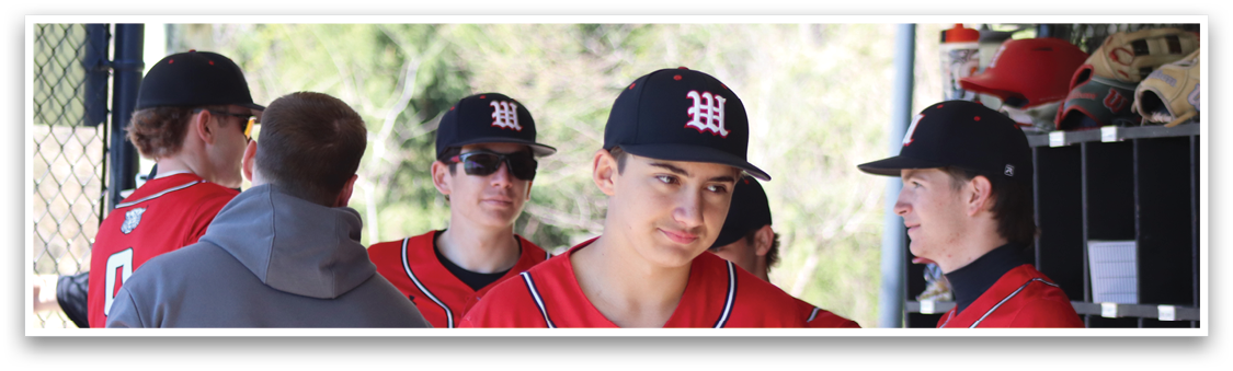 A group of baseball players standing in a dugout. Description generated by AI
