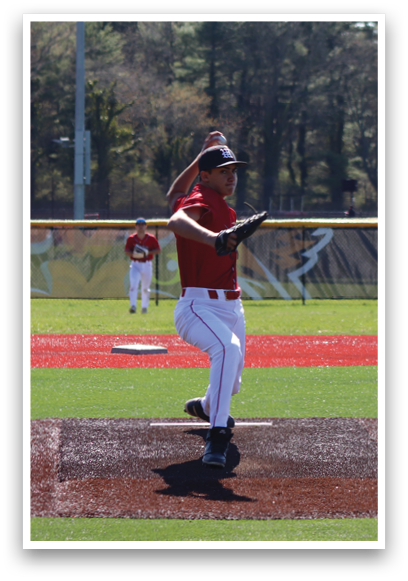 A baseball player in a red shirt and white pants is standing on the pitcher's mound. Description generated by AI