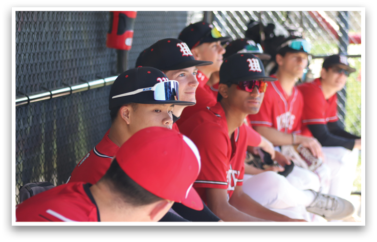 A group of baseball players sitting on a bench. Description generated by AI