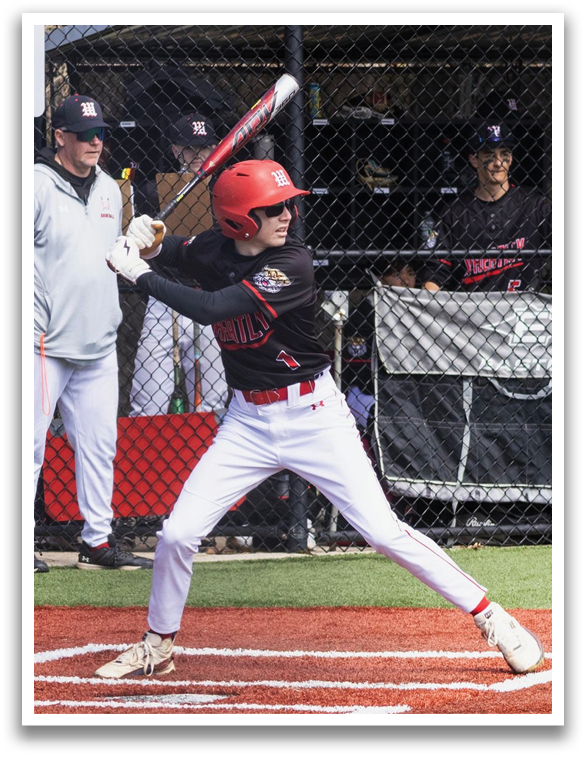 A baseball player in a black and red jersey is swinging a bat. Description generated by AI
