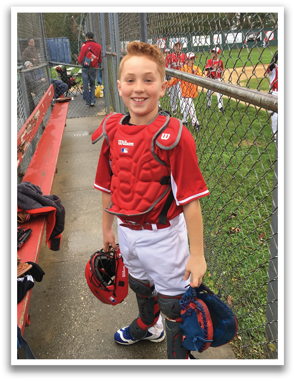 A young boy wearing a baseball glove and a red shirt. Description generated by AI