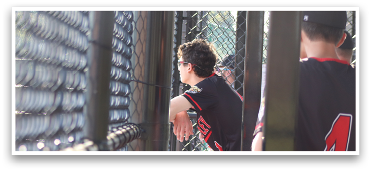A baseball player wearing a black shirt and red pants. Description generated by AI