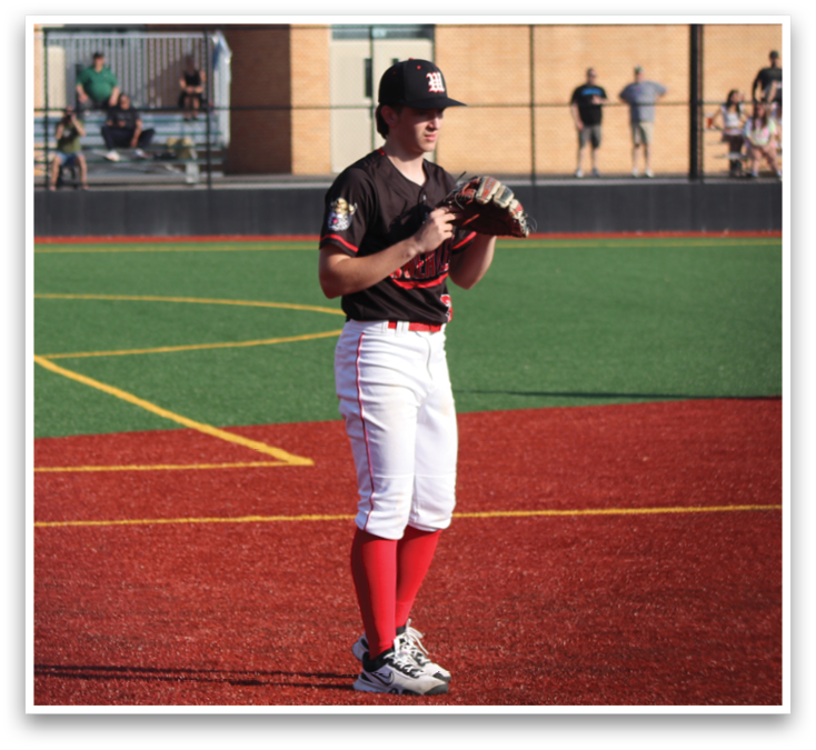 A baseball player in a black and red uniform holding a mitt. Description generated by AI