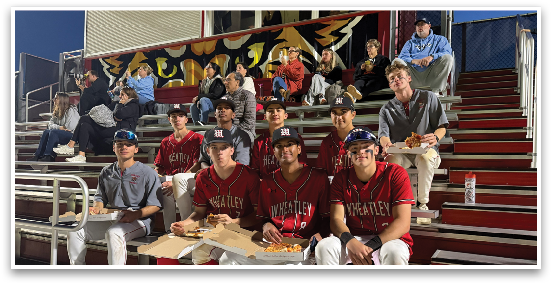 A group of baseball players sitting on a bench. Description generated by AI