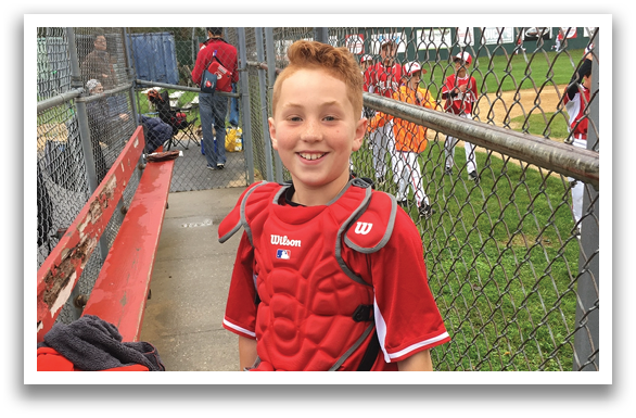 A boy wearing a baseball glove and a red shirt. Description generated by AI