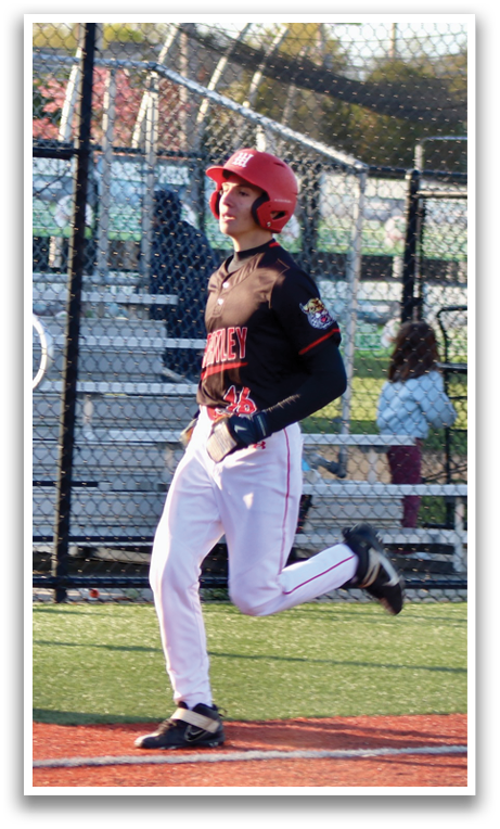 A baseball player in a black and red uniform is swinging a bat. Description generated by AI
