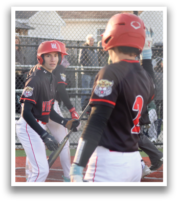 A baseball player in a black and red jersey is pitching a ball. Description generated by AI