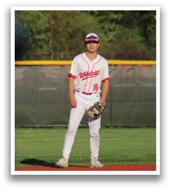 A baseball player in a red and white uniform standing on a baseball field. Description generated by AI