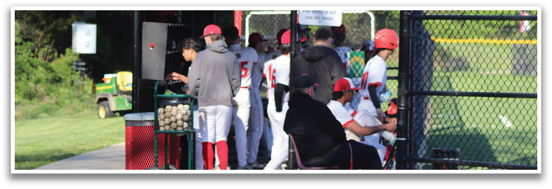 A group of people are standing outside of a baseball field. Description generated by AI