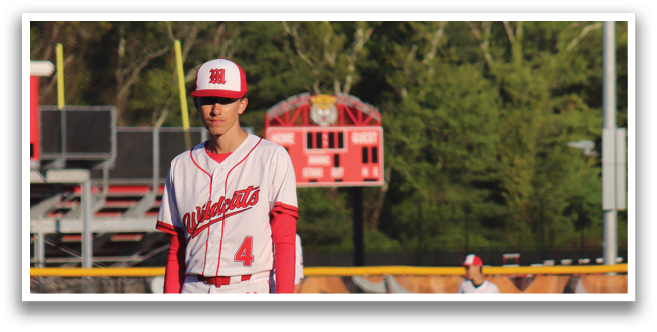 A baseball player in a red and white uniform holding a bat. Description generated by AI