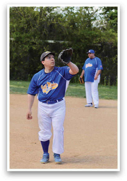 A baseball player wearing a blue shirt and white pants is standing on a field. Description generated by AI