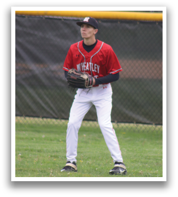 A baseball player in a red and white uniform is standing in the grass. Description generated by AI