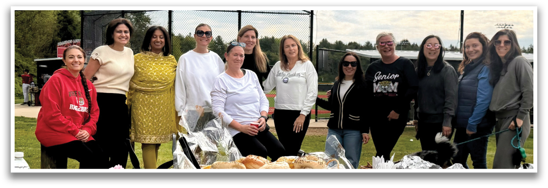 A group of women standing around a table with a tarp on it. Description generated by AI
