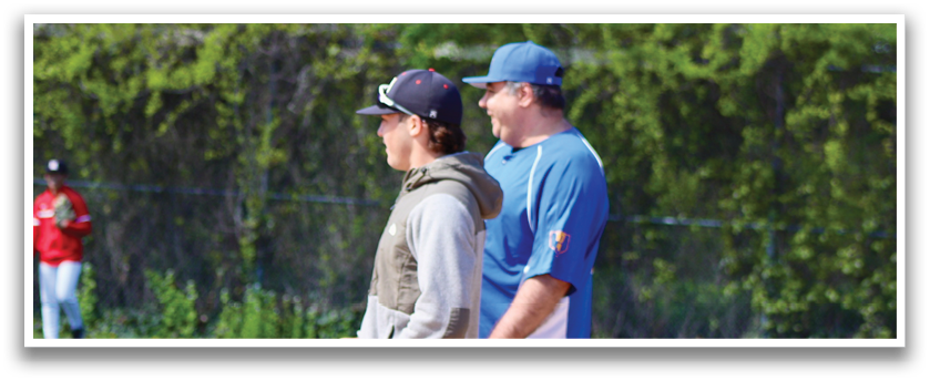 Two men standing on a baseball field. Description generated by AI