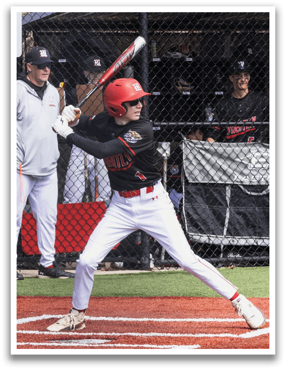 A baseball player in a black and red jersey is swinging a bat. Description generated by AI