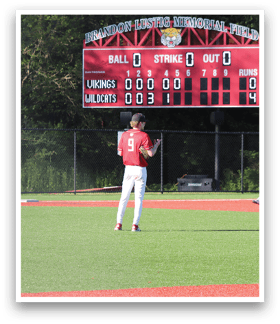 A baseball field with a scoreboard showing the score of 0-0. Description generated by AI