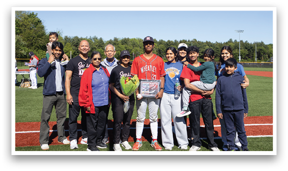 A group of people standing on a baseball field. Description generated by AI