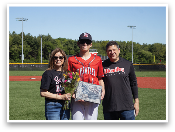 A man, woman, and boy are standing on a baseball field. Description generated by AI