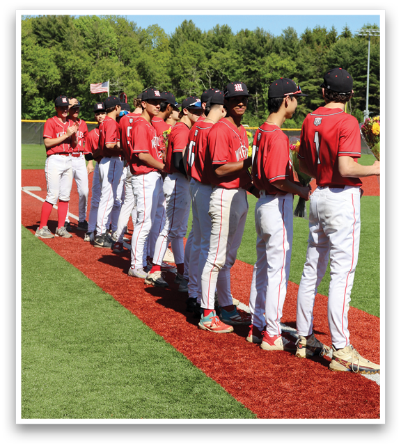 A group of baseball players standing on a field. Description generated by AI