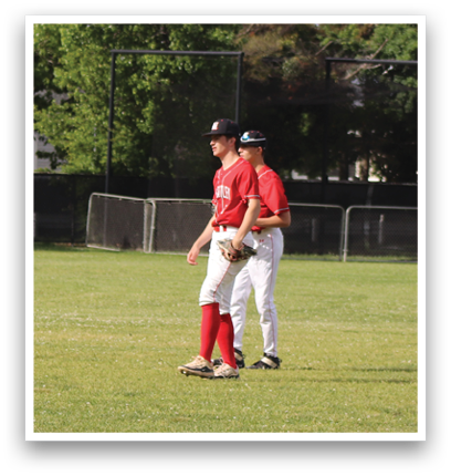 A group of young men playing baseball in a field. Description generated by AI
