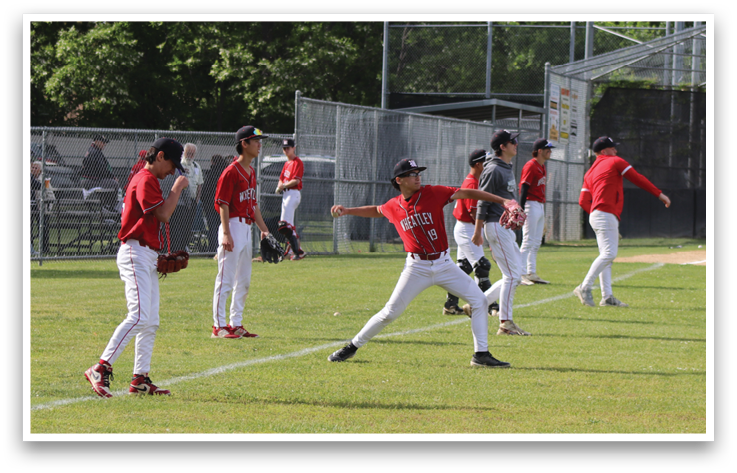 A group of young men playing baseball on a field. Description generated by AI