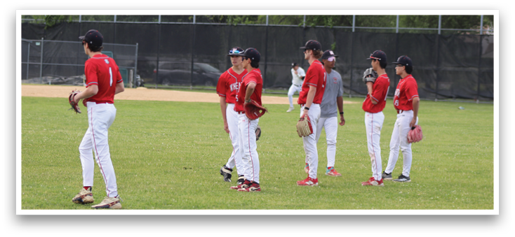 A group of young men wearing red and white uniforms are standing on a grassy field. Description generated by AI