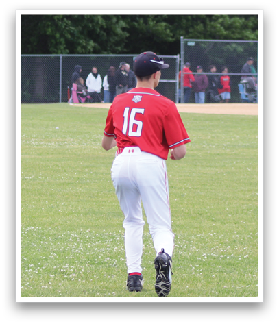 A baseball player wearing a red shirt and white pants. Description generated by AI