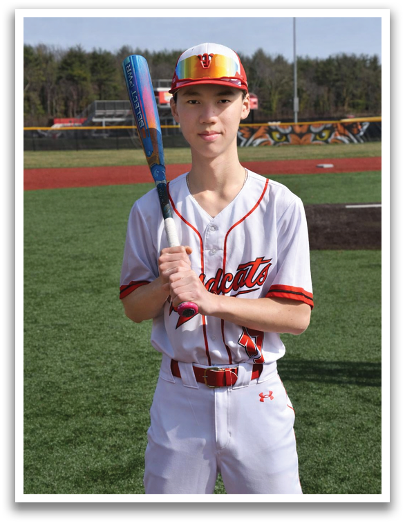 A baseball player in a white uniform holding a bat. Description generated by AI