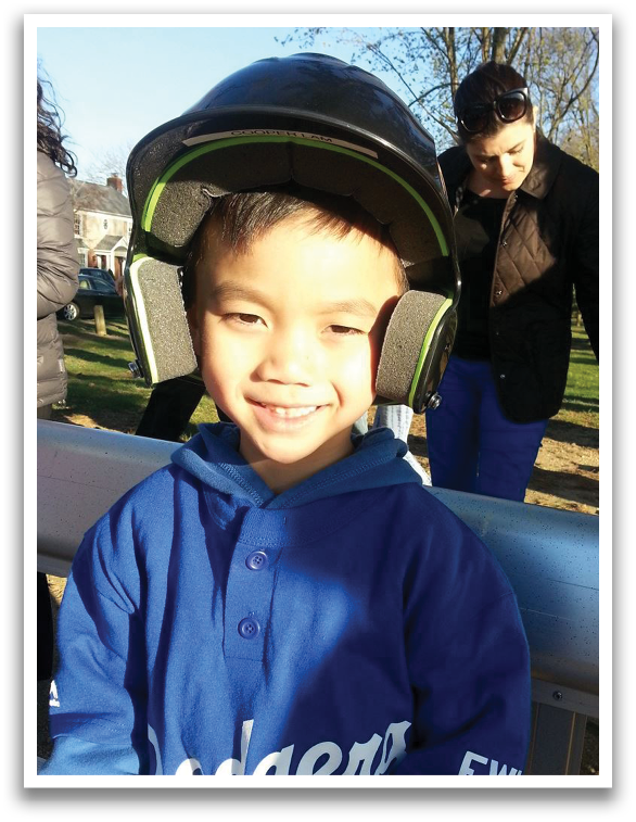 A young boy wearing a blue shirt with the word Dodgers on it. Description generated by AI