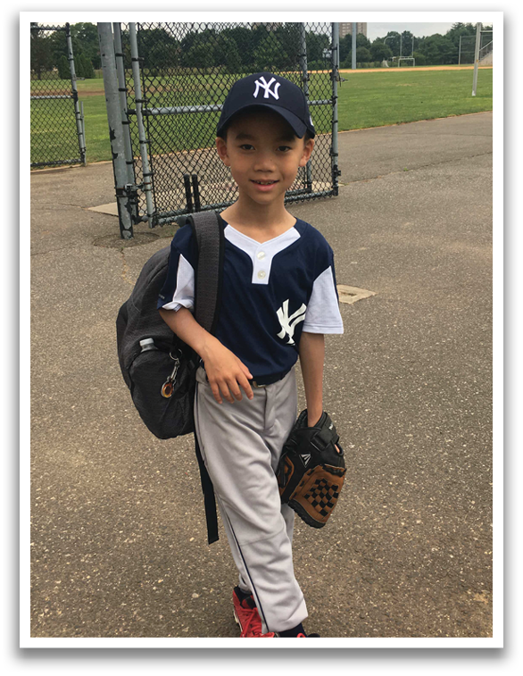 A young boy wearing a baseball uniform and holding a baseball glove. Description generated by AI
