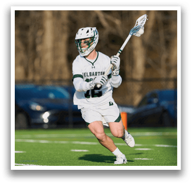 A man wearing a white shirt and shorts is holding a lacrosse stick and running on a field. AI generated content
