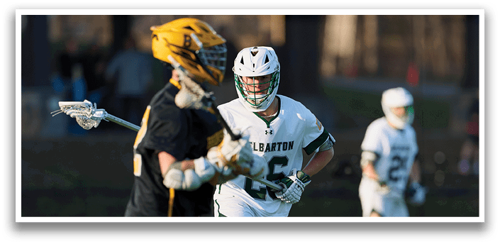 Two men playing lacrosse on a field. One man is wearing a yellow shirt and black shorts. The other man is wearing a white shirt and green shorts. AI generated content