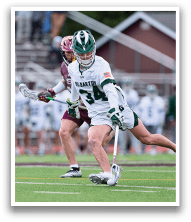 A man in a white uniform is playing lacrosse, holding a stick and running towards the goal. AI generated content
