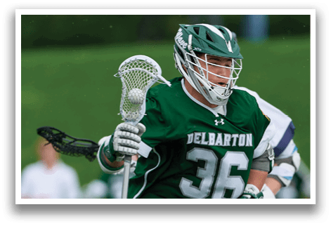 A man wearing a green jersey and white shorts is running on a field while holding a lacrosse stick. AI generated content